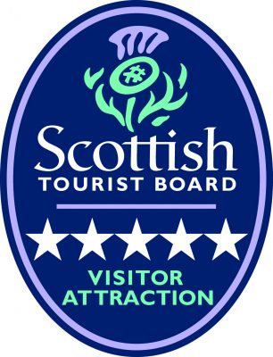 Logo of the Scottish Tourist Board, a navy oval with a thistle image and the words 'Scottish Tourist Board' sitting above 5 white stars and the words 'Visitor Attraction'.