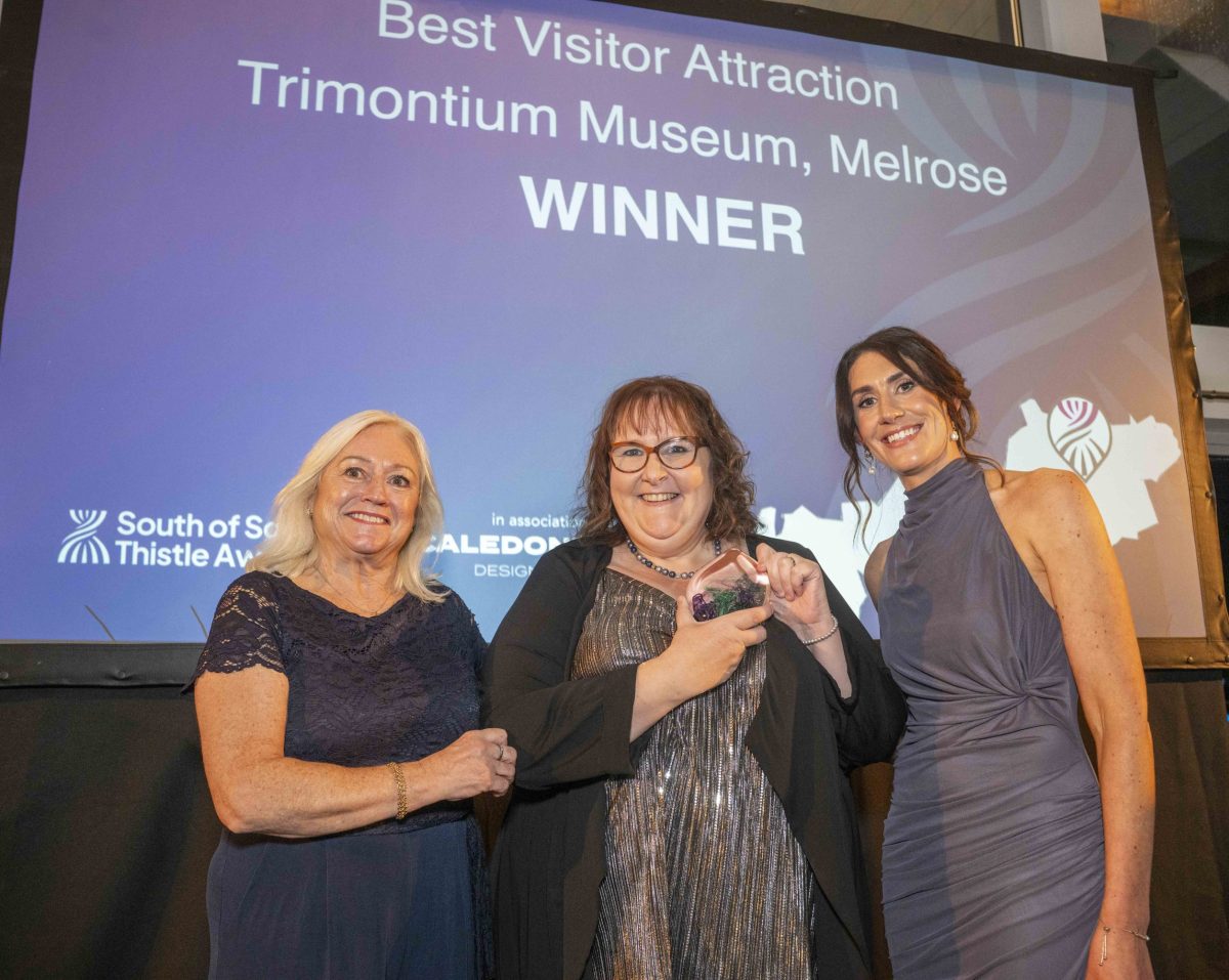 Volunteer manager receiving the glass Thistlw Award for the best visitor attraction 2025