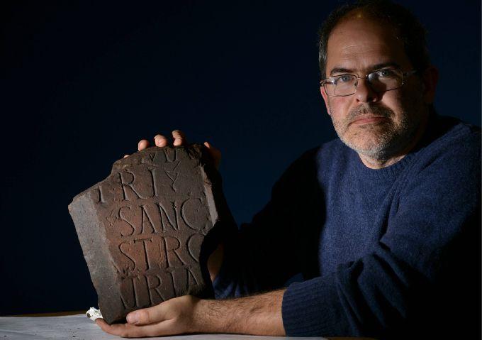 Frank Giecco holds a Roman artefact